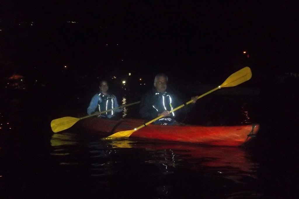 two adults kayaking in the dark