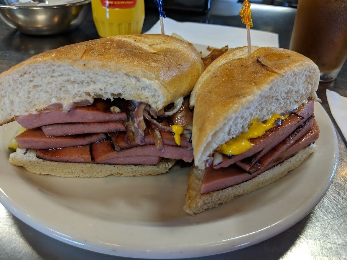 bologna sandwich cut in half with weber's yellow mustard