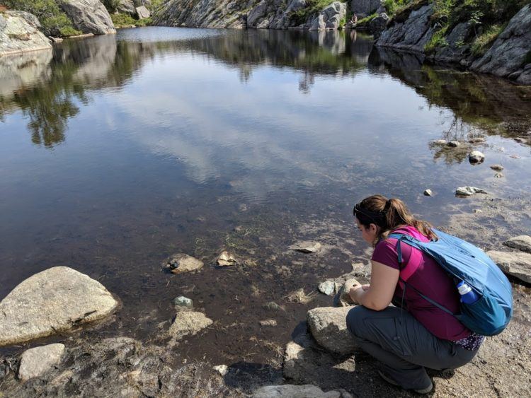 girl wearing foldaway backpack next to norway pond