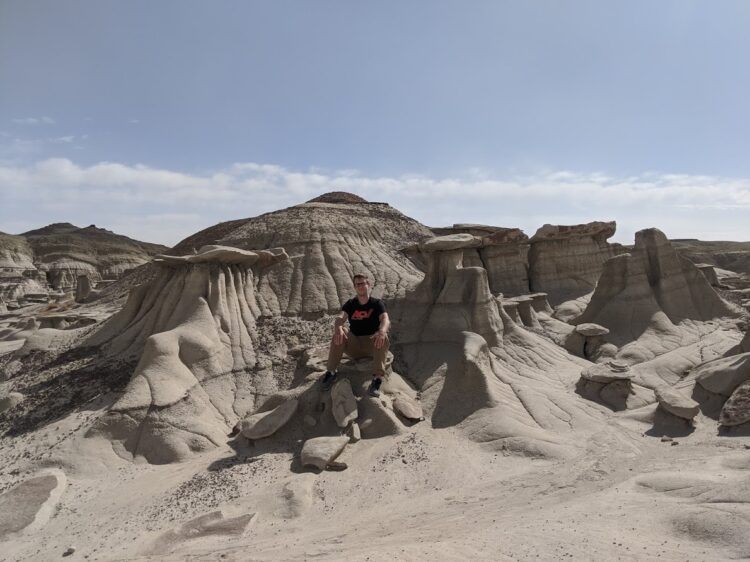 posing with rock formations in new mexico badlands