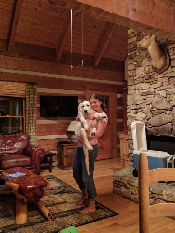 girl holding dog in cabin