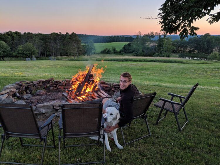dog in front of firepit at sunset
