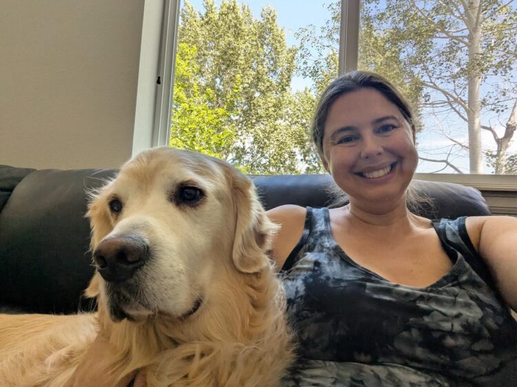 pregnant woman sitting on the couch with her dog